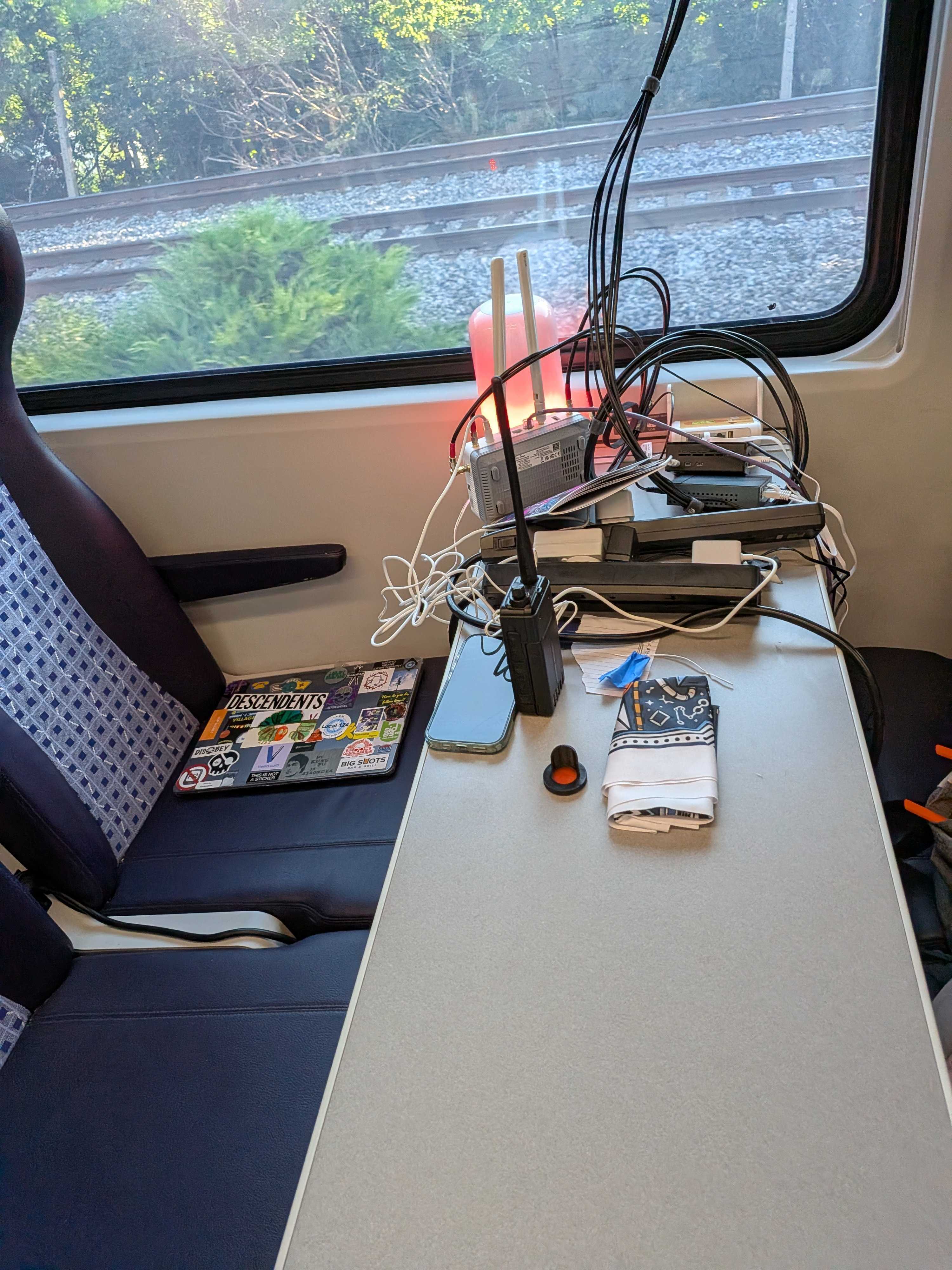 Routers, switches, radios, and cables stacked on a train table