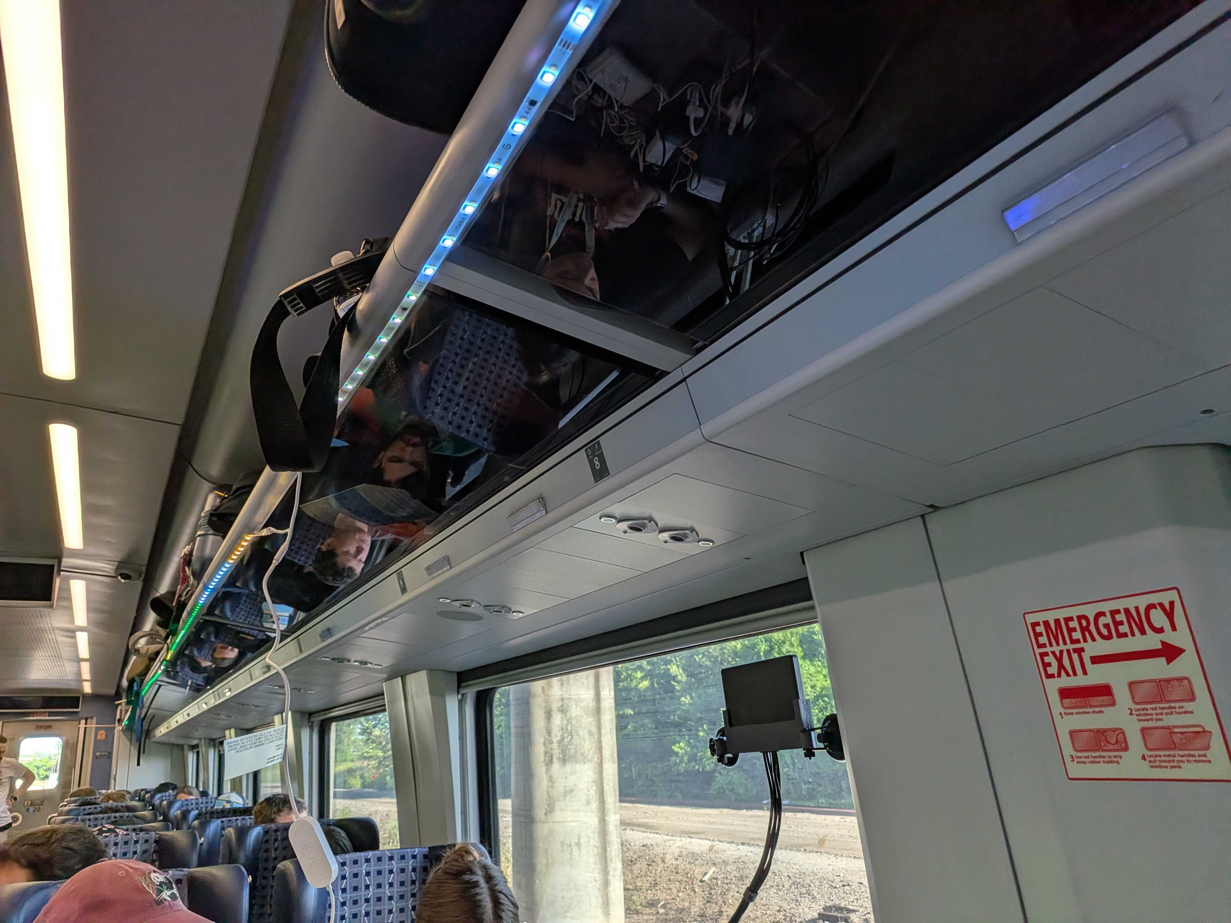 Ethernet cables and LED strips routed through the train's overhead luggage bins